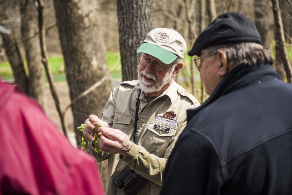 Bo Brown showing guests a small plant in his hands.