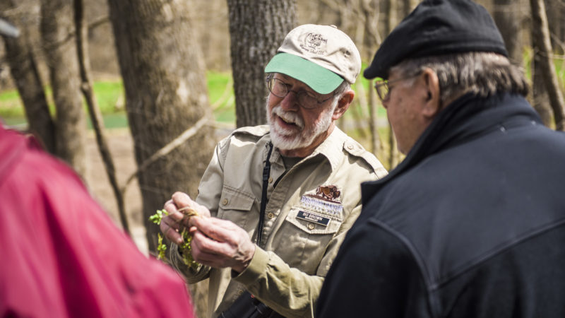 Bo Brown showing guests a small plant in his hands.
