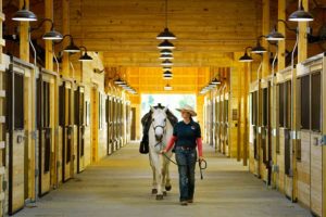 Woman walking horse at Little Indian Stables
